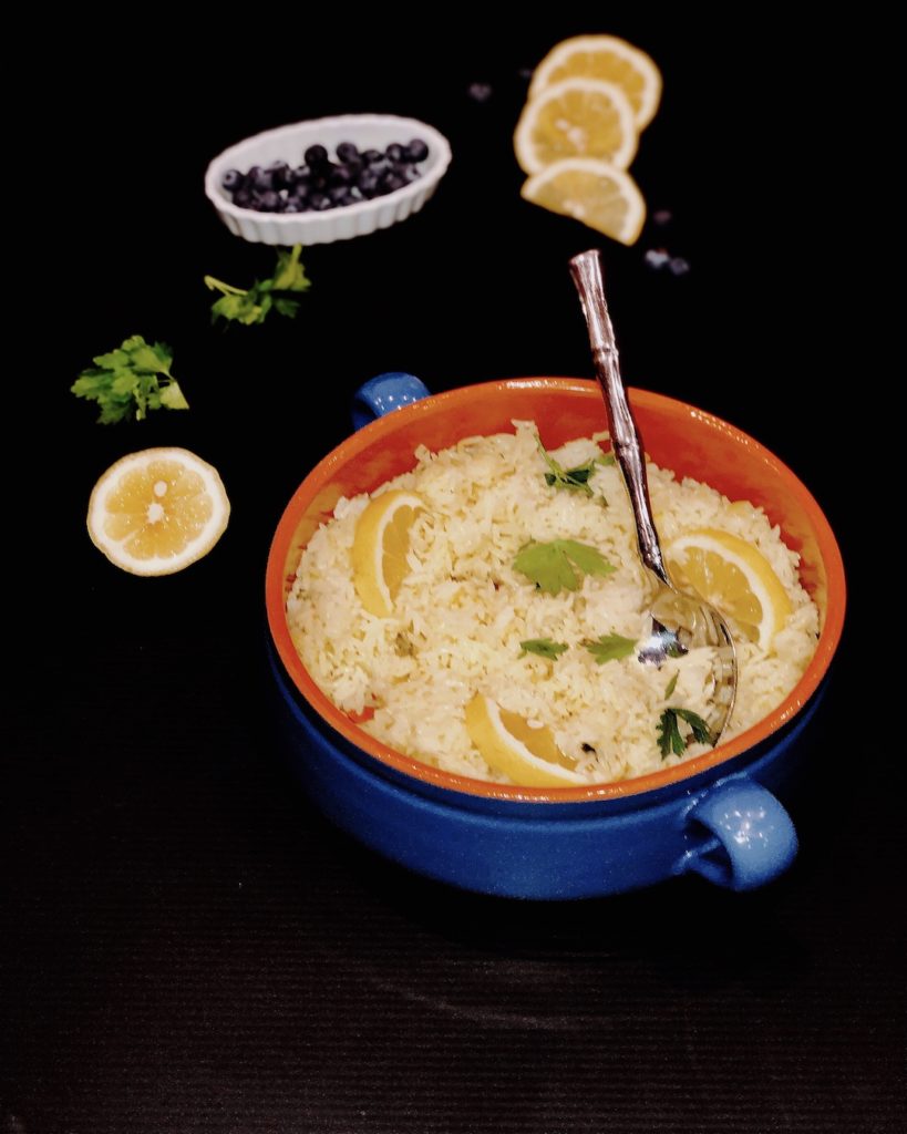lemon rice in a blue pot on black background