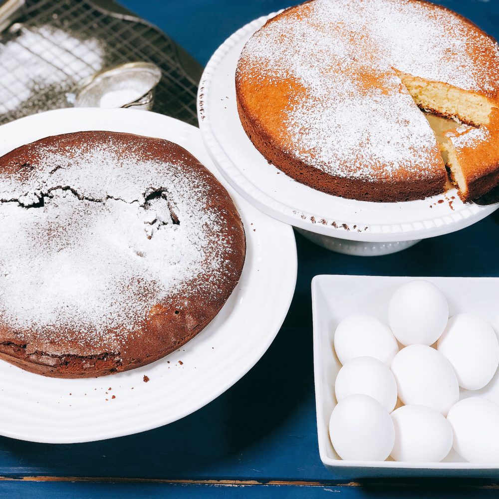 chocolate and lemon cake on white plate with eggs on the side on a blue wood table