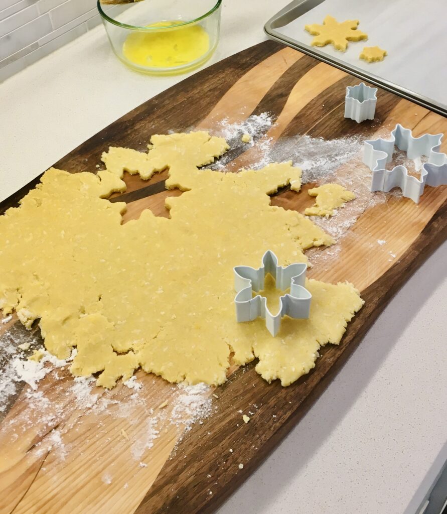 sablé cookies batter rolled out with cookies molds on it