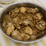 chicken yassa in a sauce pan