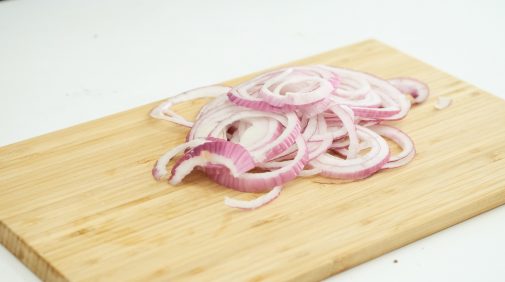 sliced onions on a wood board