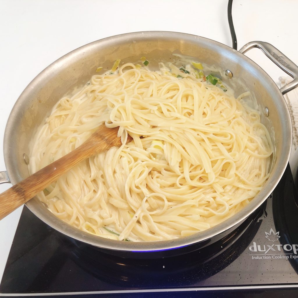 pasta in a sauce pan with white sauce