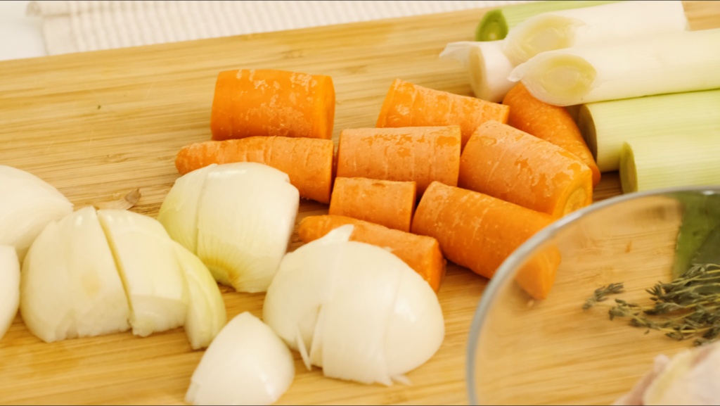 carottes, oignons, poireaux sur planche à découper