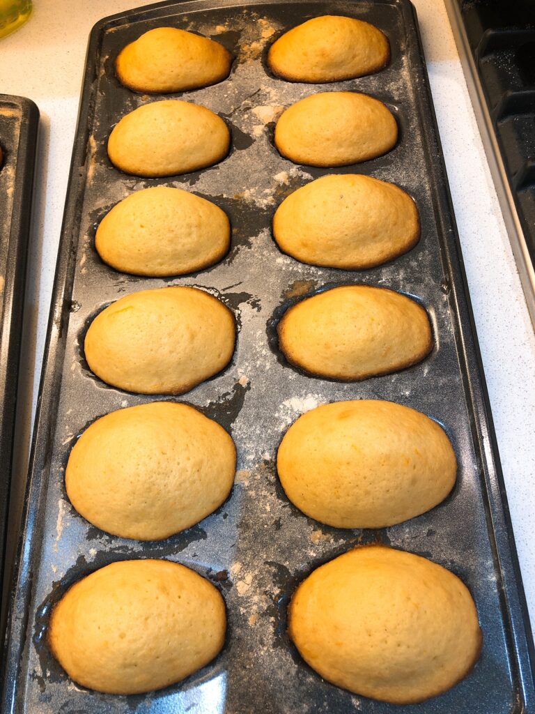 orange zest madeleines on madeleine pan