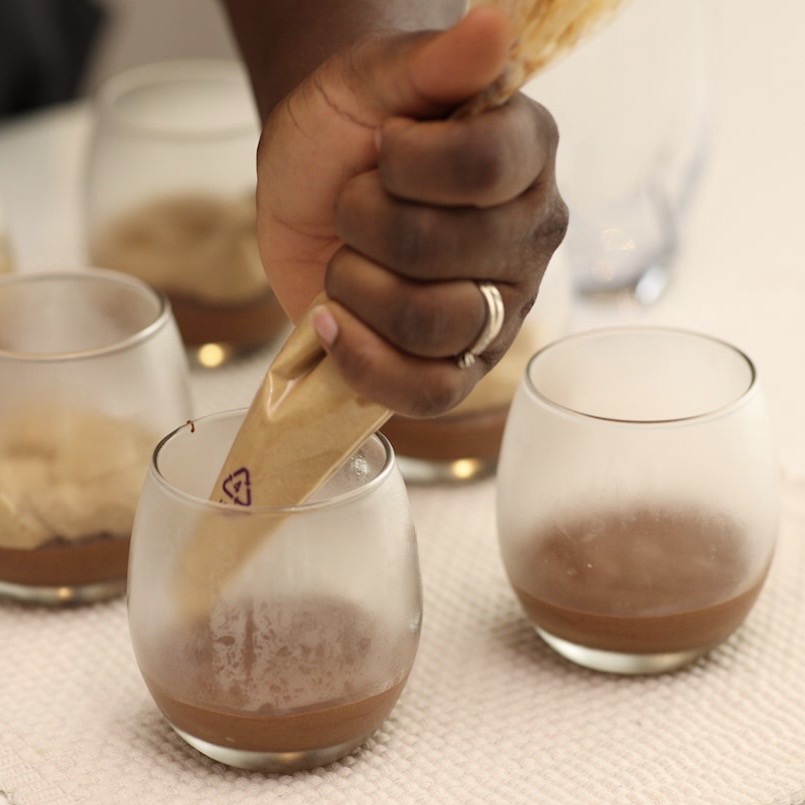 coffee mousse being poured on top of chocolate mousse