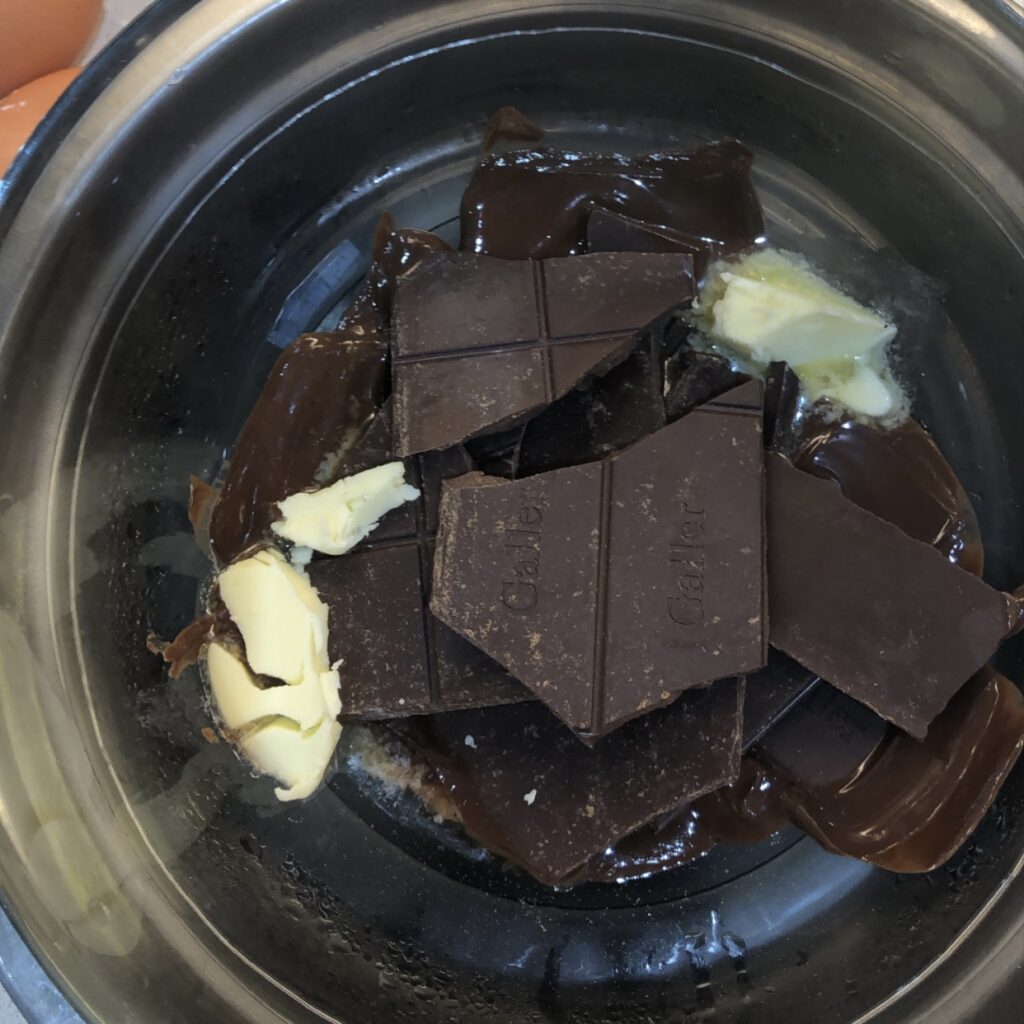 Melted 70% dark chocolate mixture being prepared for homemade chocolate crinkle cookies
