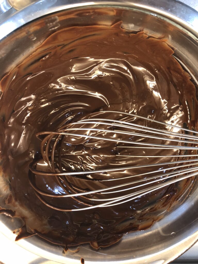 Fudgy chocolate crinkles coated in powdered sugar with crackled tops, fresh out of the oven — easy holiday cookie recipe with orange zest.
