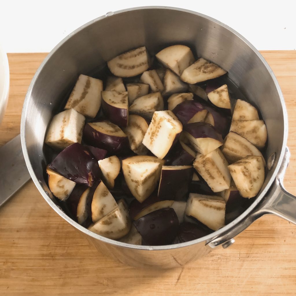 Eggplants in a small pot with water