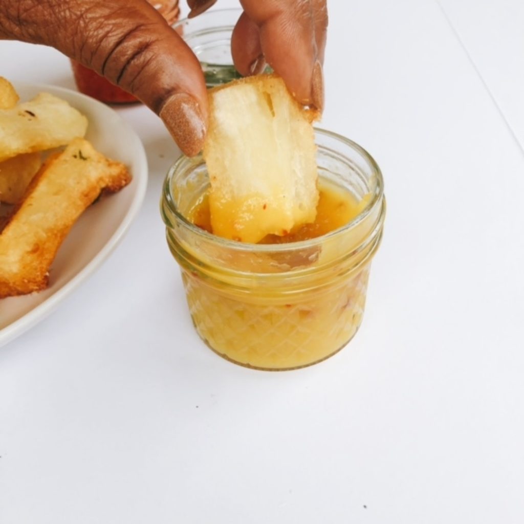 yuca trempé dans une sauce à la mangue