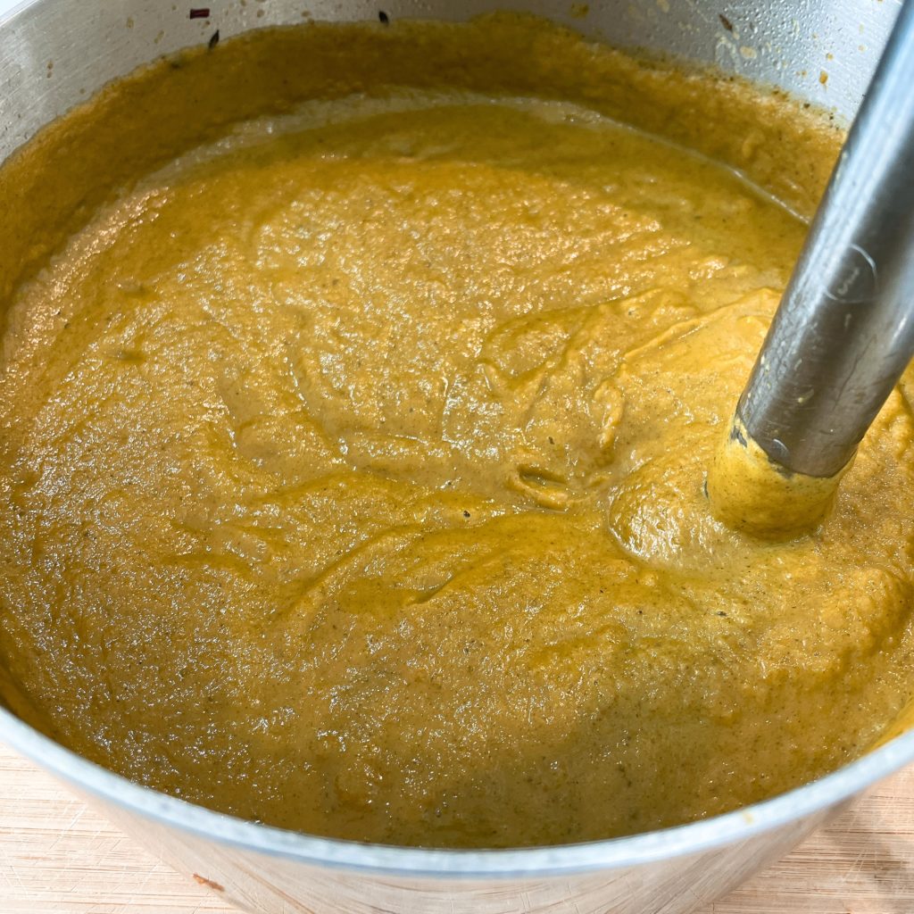 mixing amaranth soup with a hand mixer