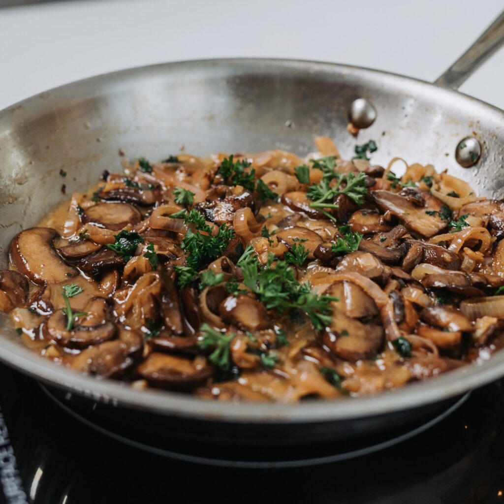 cooked mushrooms in sauce pan on stove