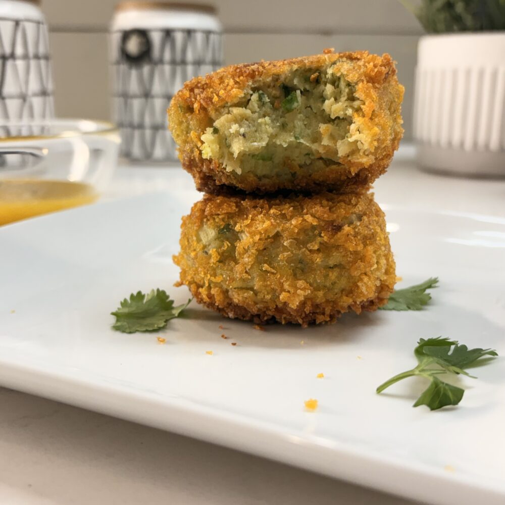 Plantain patties stacked on a white plate