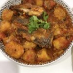 boiled plantains with tilapia in grey bowl.