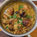 Chicken Thighs with coconut milk in a sauce pan.