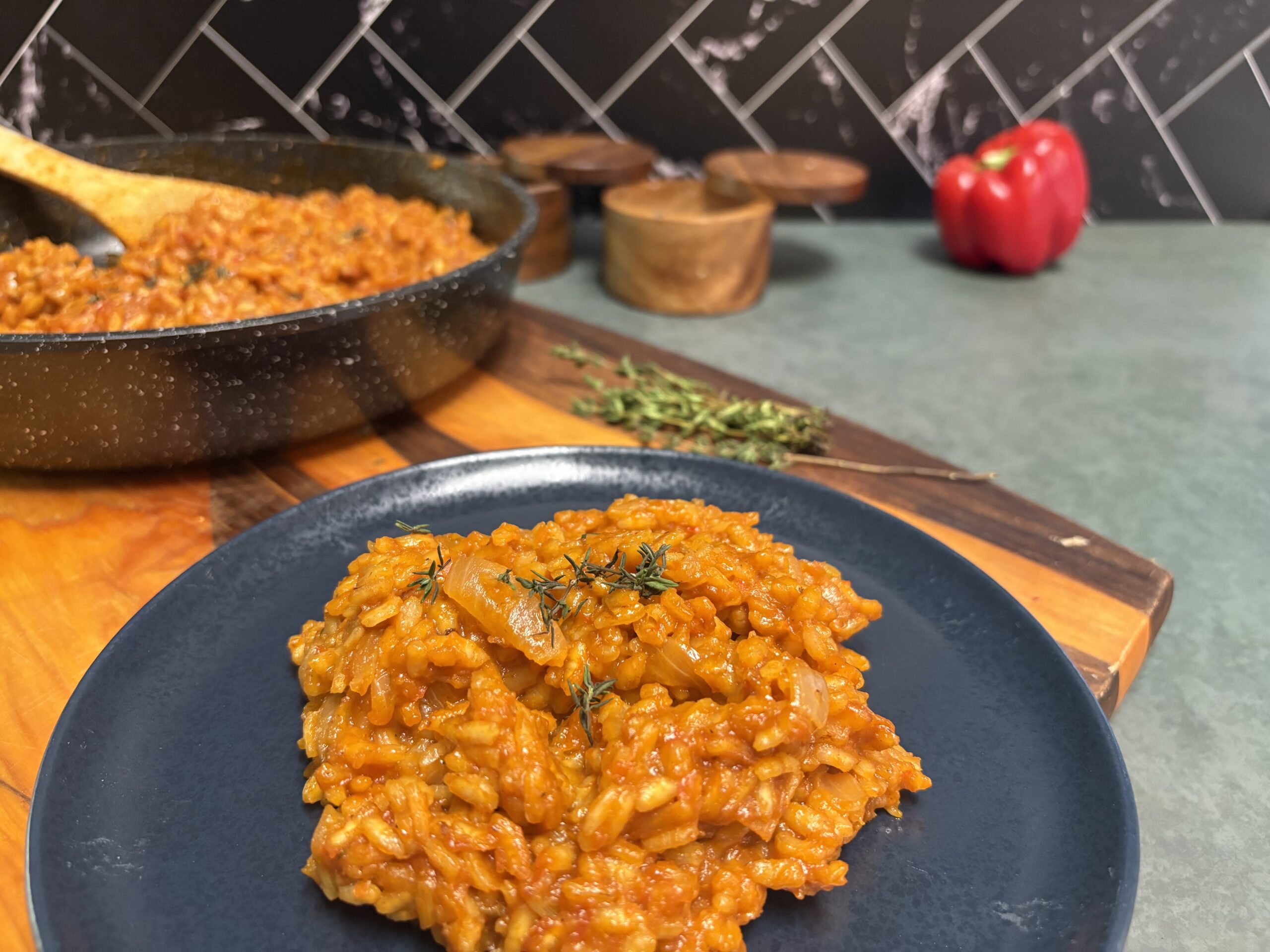 jollof risotto on a blue plate with green counter top