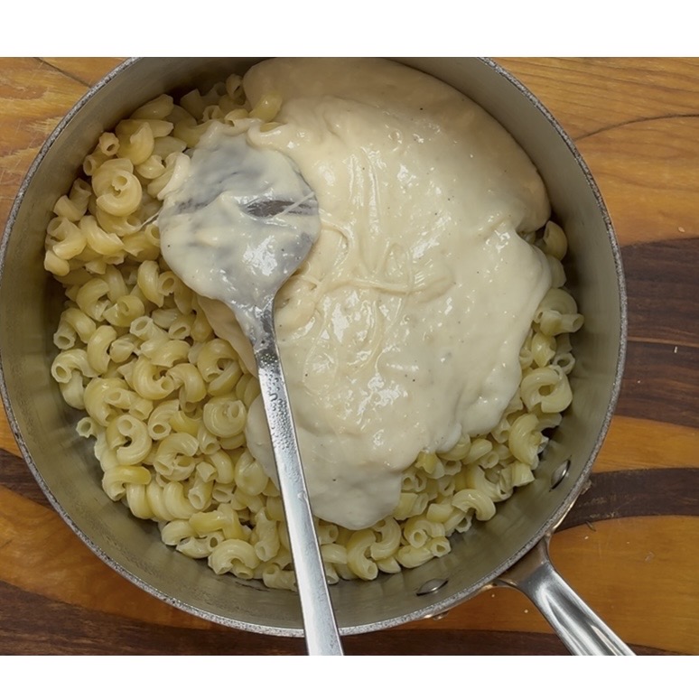 cheese sauce over macaroni in a pot