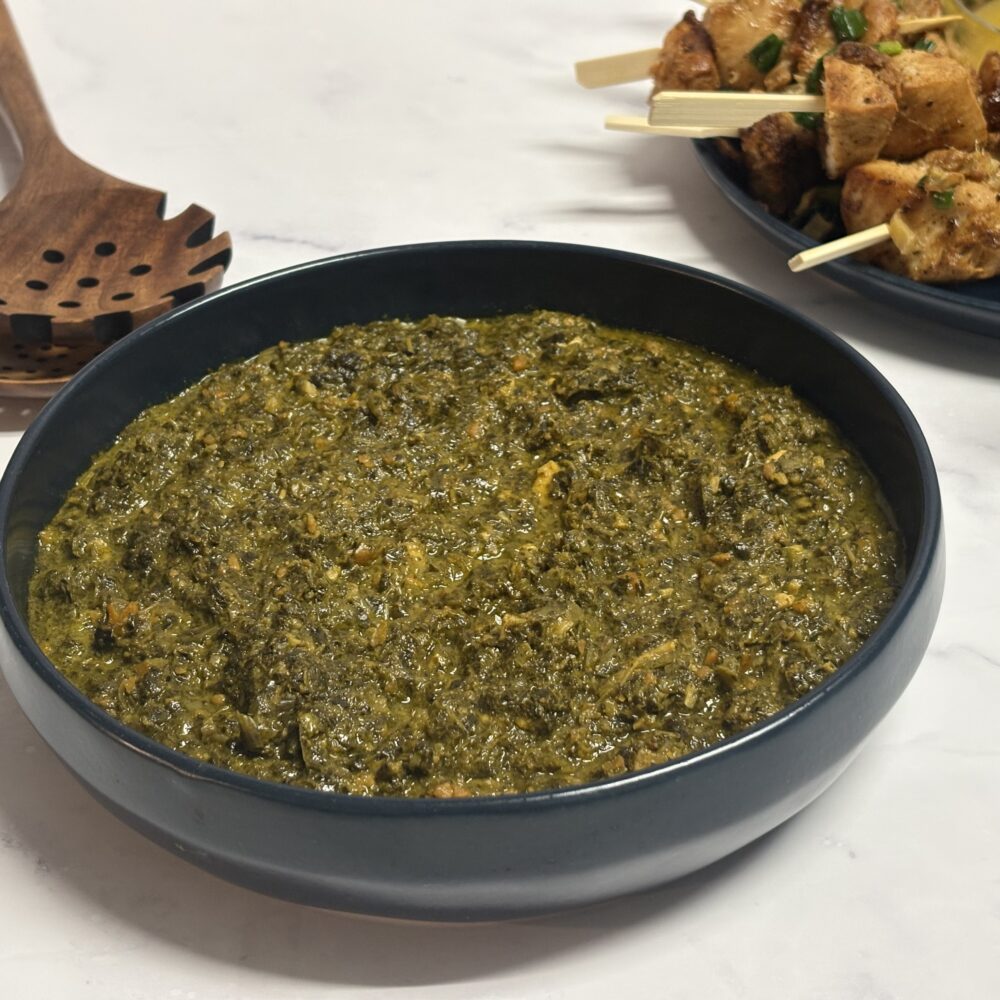 Pondu with grounded peanuts in blue bowl next to chicken kebabs plate
